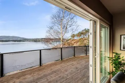an open door to a balcony with a view of the water at Luxury Seafront Villa with Panoramic Views in Veland