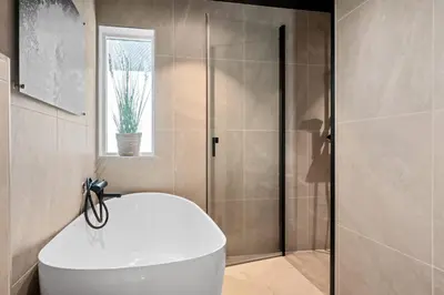 a bathroom with a shower with a toilet and a sink at Luxury Seafront Villa with Panoramic Views in Veland