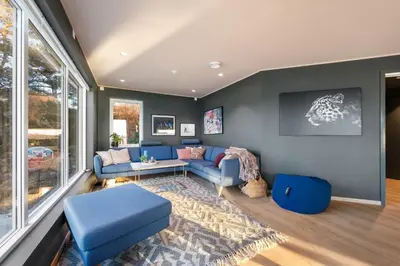 a living room with a blue couch and a table at Luxury Seafront Villa with Panoramic Views in Veland