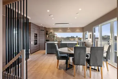 a kitchen and dining room with a table and chairs at Luxury Seafront Villa with Panoramic Views in Veland