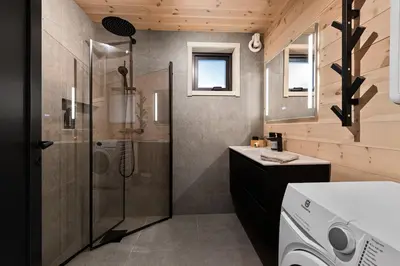 a bathroom with a shower and a washing machine at Skarhaug Panorama Lodge in Stranda