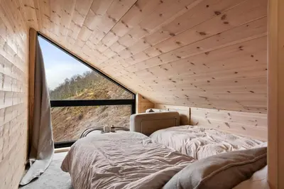 a bedroom with a bed and a large window at Skarhaug Panorama Lodge in Stranda