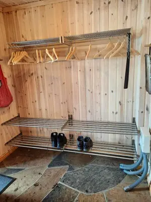a room with a wooden wall with a bench with shoes at Familiehytte på Botn, Vågslid til leie in Botn