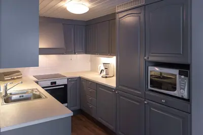a kitchen with blue cabinets and a sink and a microwave at Bakkebyvegen 22A in Trysil
