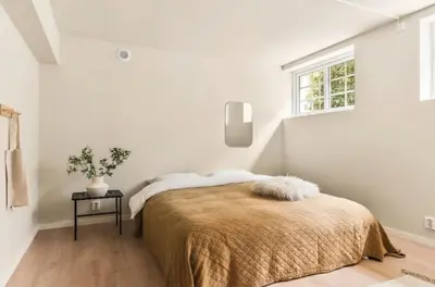 a white bedroom with a bed and a window at Lev livet i Bergen - Stor moderne leilighet in Bergen