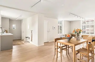 a kitchen and a living room with a table and chairs at Lev livet i Bergen - Stor moderne leilighet in Bergen