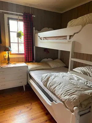 a bedroom with two bunk beds and a window at Nedre Flaata Seter in Nørdstebø