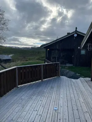 a wooden deck with a wooden fence and a barn at Nedre Flaata Seter in Nørdstebø