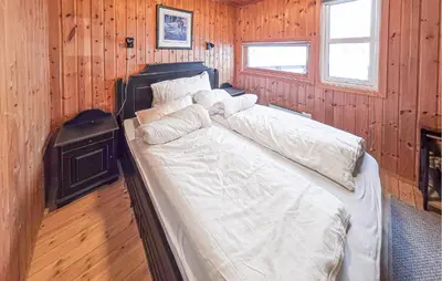 a bed in a room with wood paneled walls at 4 Bedroom Awesome Home In Rjukan in Rjukan