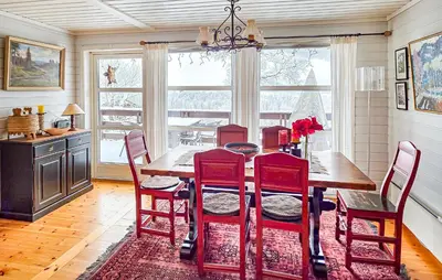a dining room with a wooden table and red chairs at 4 Bedroom Awesome Home In Rjukan in Rjukan