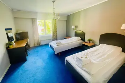 a hotel room with two beds and a television at Suldal Hotell in Sand