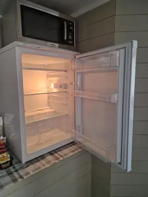 an empty refrigerator with its door open in a kitchen at Cosy living room, bedroom and bathroom and kitchen area in Kolavåg