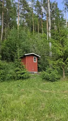 a red shed in the middle of a field at Cozy Off-Grid Cabin - No Power, No Running Water