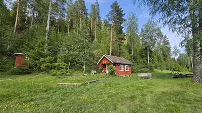 a small red cabin in the middle of a field at Cozy Off-Grid Cabin - No Power, No Running Water