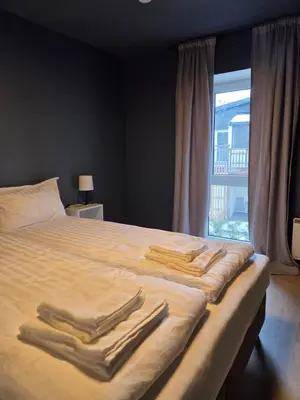 a bedroom with a bed with three towels on it at Central 2-Bedroom Apartment in Voss in Vossevangen