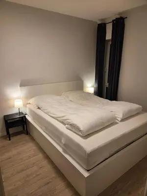 a white bed in a room with a window at Central 2-Bedroom Apartment in Voss in Vossevangen