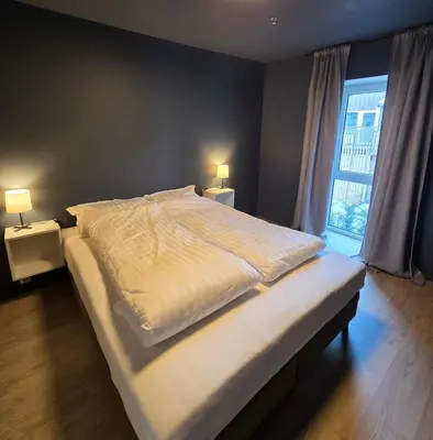a large bed in a bedroom with two lamps at Central 2-Bedroom Apartment in Voss in Vossevangen