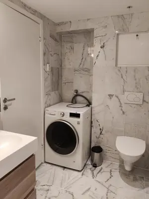 a washing machine in a bathroom with a toilet at Central 2-Bedroom Apartment in Voss in Vossevangen