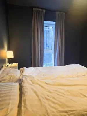 a bedroom with a white bed and a window at Central 2-Bedroom Apartment in Voss in Vossevangen
