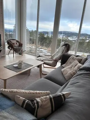 a living room with a couch and a large window at Hytte Hummelfjell, Os in Os