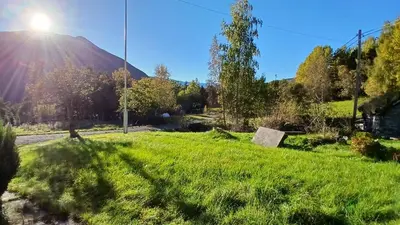 a grassy field with a mountain in the background at The house by the waterfall in Breim
