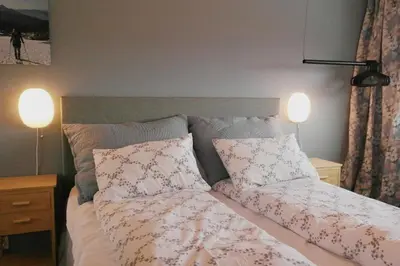 a bedroom with a bed with two pillows and two lamps at Modern, spacious top apartment in Lii