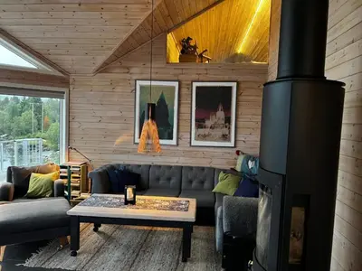 a living room with a couch and a fireplace at Lunvik - Flott hytte ved Nysætervatnet in Sykkylven
