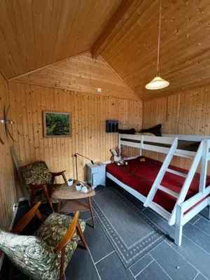 a bedroom with a bed and a table and chairs at Lunvik - Flott hytte ved Nysætervatnet in Sykkylven