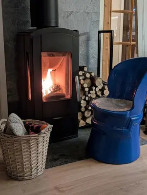 a blue chair in front of a fire place at Rasteplassen