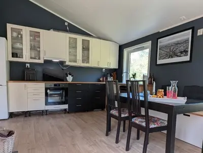 a kitchen with a table and chairs in a room at Rasteplassen
