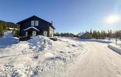 a house on a snow covered road next to a house at Gorgeous Home In Sjusjøen With Wifi in Sjusjøen