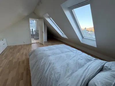 a bedroom with a bed and a large window at central apartment in Bergen and pet friendly in Bergen