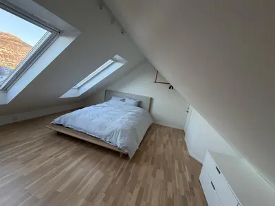 a attic bedroom with a bed and a window at central apartment in Bergen and pet friendly in Bergen