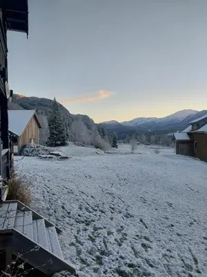 a field covered in snow with mountains in the background at Llama Lodge 8 beds 4 Bedrooms in Kleivane