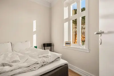 a white bed in a room with a window at City Center Apartment - Top location in Bergen