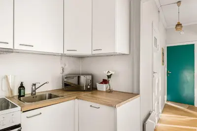 a white kitchen with a sink and a microwave at City Center Apartment - Top location in Bergen