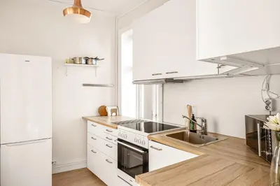a white kitchen with a sink and a stove at City Center Apartment - Top location in Bergen