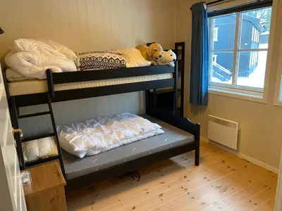 two bunk beds in a room with a window at Leilighet i Fageråsen, Trysil, med ski inn og ut in Trysil