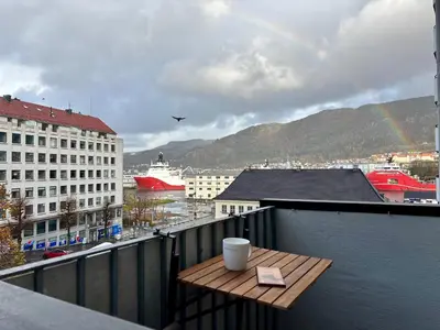 a table on a balcony with a view of a city at Corner apartment with balcony in Bergen in Bergen