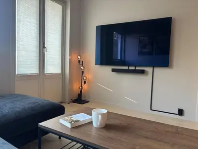 a living room with a flat screen tv on a wall at Corner apartment with balcony in Bergen in Bergen