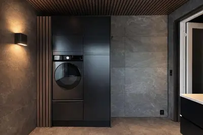a kitchen with a washer and dryer in a wall at Private house on cider farm - fjord, beach & jetty in Sogndal