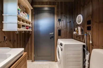 a kitchen with a washer and dryer next to a door at Lykka - lovely cabin with amazing view in Torpo