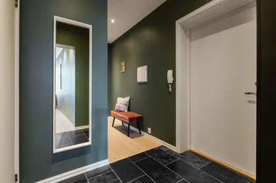 a hallway with a chair and a mirror at NEW! I Modern Comfort in the Heart of Bergen in Bergen