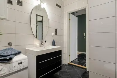a white bathroom with a sink and a mirror at NEW! I Modern Comfort in the Heart of Bergen in Bergen