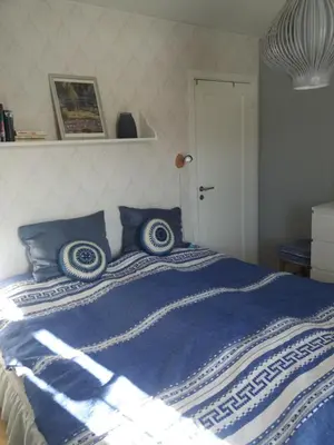 a blue and white bed with blue pillows on it at Synnseter in Lii