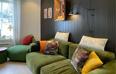 a living room with a green couch with colorful pillows at Beach Front Home In Rovde With Wifi in Rovde