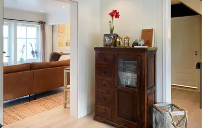 a living room with a couch and a wooden cabinet at Beach Front Home In Rovde With Wifi in Rovde