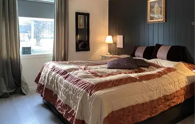 a bedroom with a large bed with a window at Beach Front Home In Rovde With Wifi in Rovde