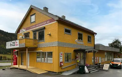 a yellow building with a gas station in front of it at Gorgeous Apartment In Verma With Wifi in Verma