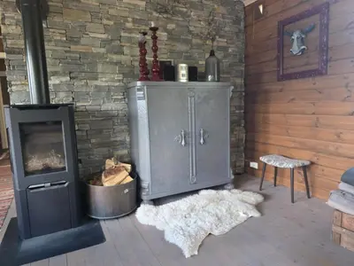 a living room with a fireplace and a stove at Kilodden, Lakeside Mountain Cabin with Stunning Views in Tuddal